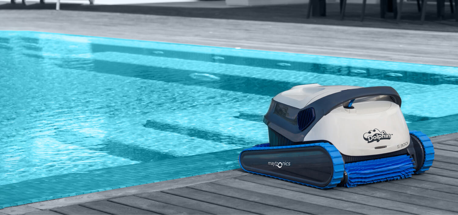 One of the Dolphin S300i robotic cleaners rests beside the pool.